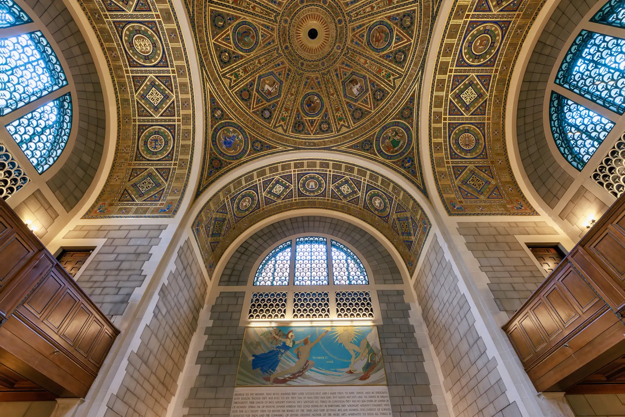 Stepping inside reveals the Great Hall in full scale—where massive stone arches and a Prometheus mural give way to the luminous tile dome above.